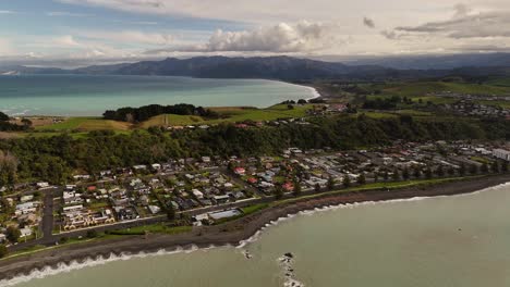 kaikoura coastal town, bay, dark beach, peninsula, new zealand. aerial backward