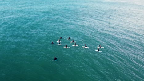 Toma-Aérea-De-Drones-De-Un-Grupo-De-Surfistas-Y-Bodyboarders-Esperando-En-Fila-Arrecife-De-La-Costa-Central-Océano-Pacífico-Nsw-Australia-4k