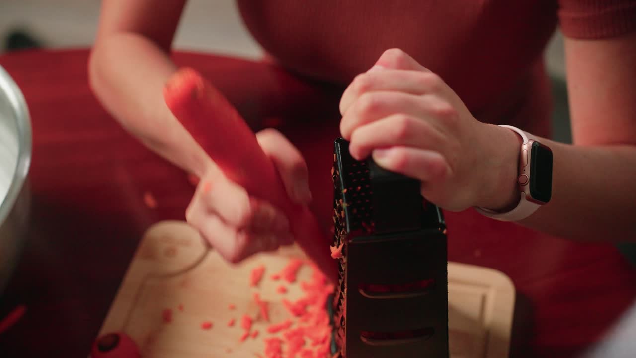 치즈 그레이터 를 사용 하여 당근 을 손 으로 는 여자