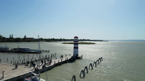 Aerial-drone-shot-of-a-lighthouse-on-a-lake