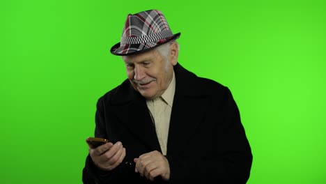 anciano elegante abuelo caucásico hombre usando teléfono inteligente para comprar en línea