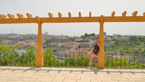 shot of a woman watching from porto side of vila nova de gaia across douro river in porto, portugal on a sunny day