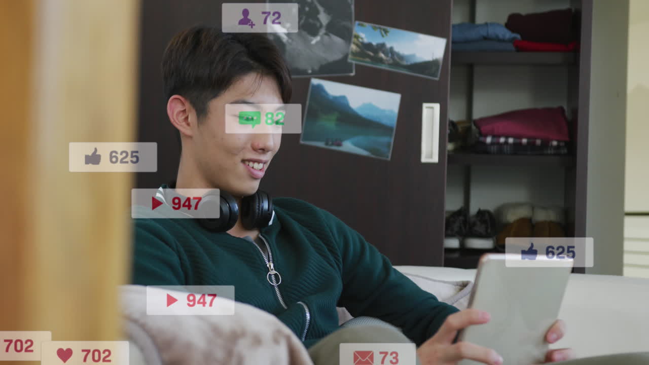 알림 바의 애니메이션, 소파에 앉아 디지털 태블릿에서 스크롤하는 미소 짓는 아시아 소년