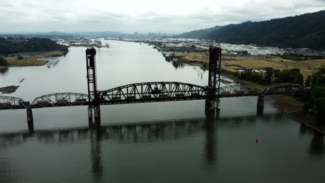 us, oregon, portland, st johns, 2025-07-26 - drone view of a freight train going across the train bridge