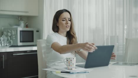 mujer enojada tiene problemas con el trabajo en línea en la computadora portátil en casa