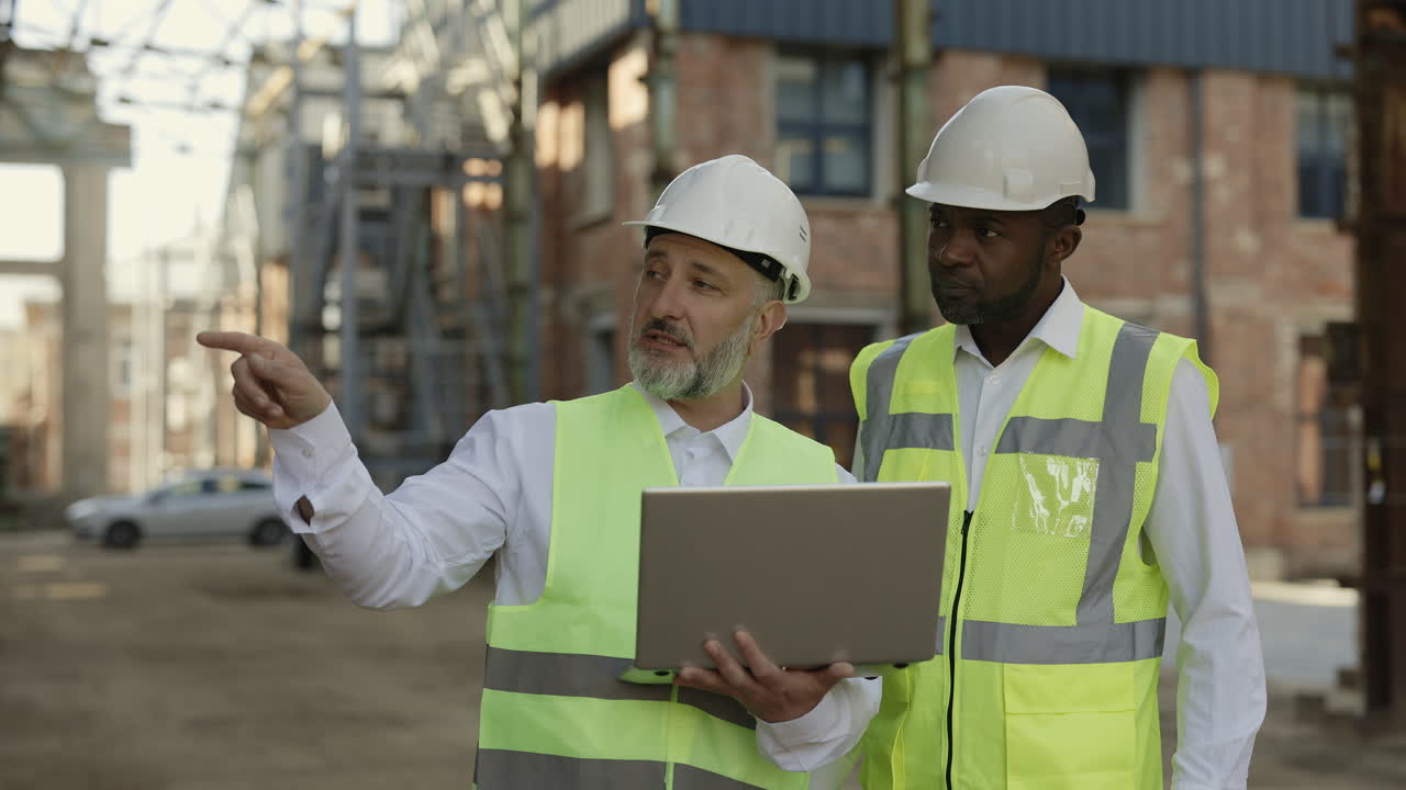 Construction Workers Reviewing Project on Laptop at a Power Plant