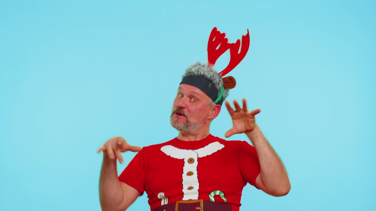 크리스마스 티셔츠를 입은 남자는 이어폰을 통해 음악을 듣고, 디스코 춤을 추며 즐거운 시간을 보내고 있습니다.