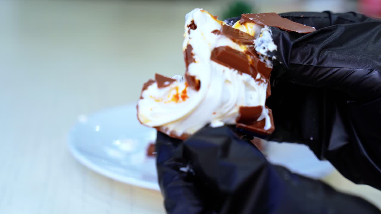 Macro shot of hands breaking soft chocolate with cream—perfect for dessert, food styling, ASMR, or culinary prep scenes.