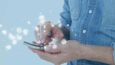 animation of multiple white spots over midsection of man using smartphone on blue background