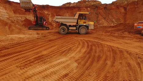 camión de minería en movimiento en una mina de arena. maquinaria de minería trabajando en una cantera de arena