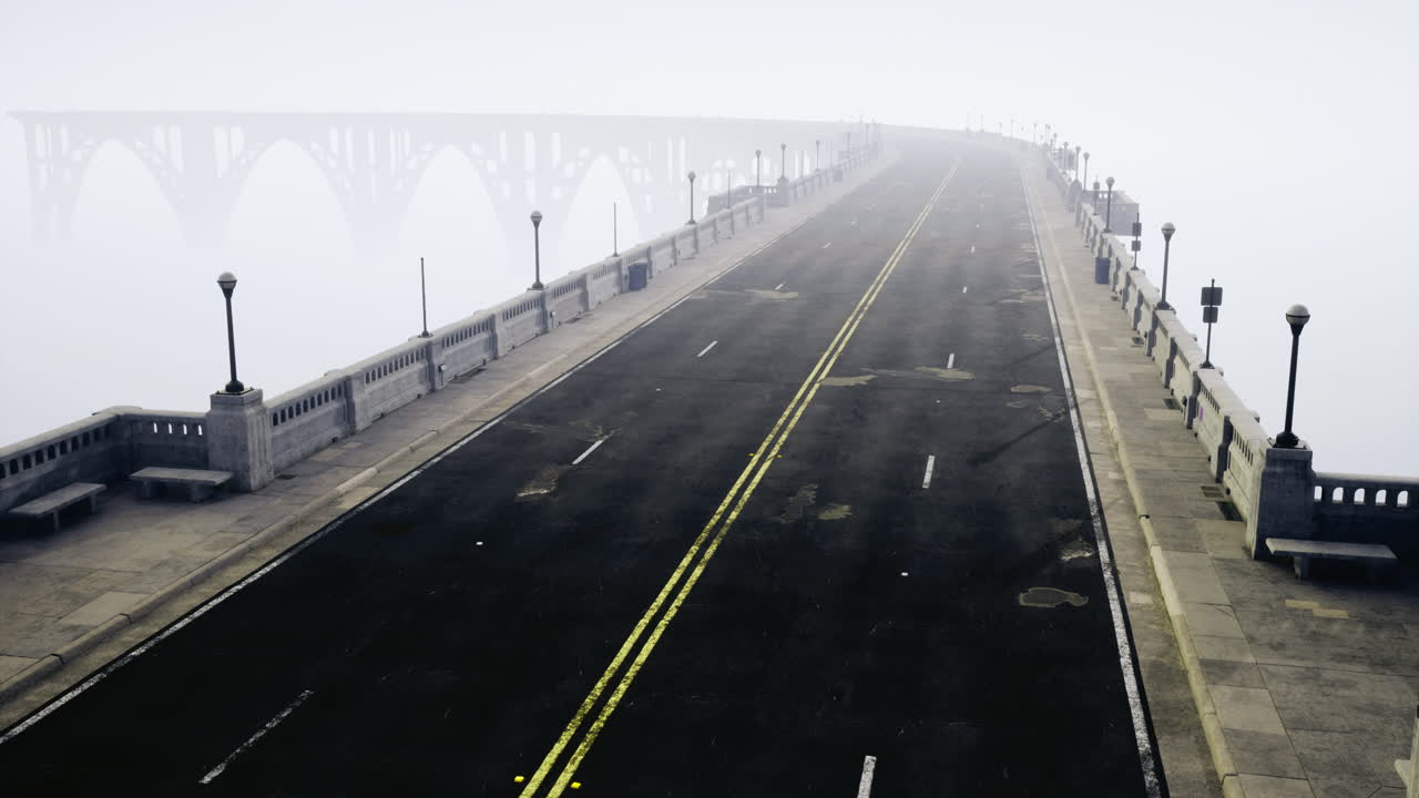 Foggy highway leading to a bridge shrouded in mist at dawn