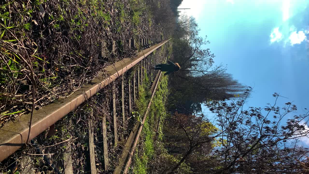 걷고 점프하는 어린 소녀를 위한 길을 안내하는 낡은 난간