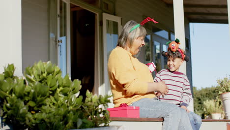 abuela y nieto bi-racial felices dando regalos de navidad, cámara lenta, espacio de copia