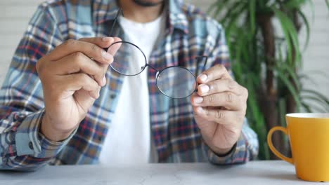 man holding round glasses