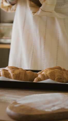 woman baking fresh croissants in her kitchen