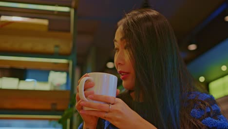 beautiful asian oriental female girl woman model in cafe restraurant with a cup of beverage drinking talks, chats, smiles, fun and dialogue, conversation