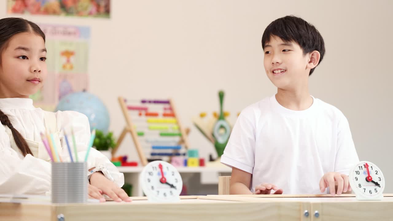 밝고 현대적인 교실에서 한 남자아이와 여자아이가 하이파이브를 하며 성공을 축하하고 있어요