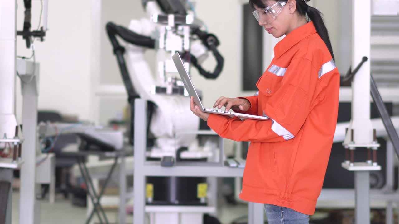 el oficial profesional comprueba el robot que se mueve en la base de la pieza en la fábrica de fabricación. reparación del brazo robótico en el laboratorio de investigación, uso de gafas de protección, uso de computadora compruebe el bucle del programa.