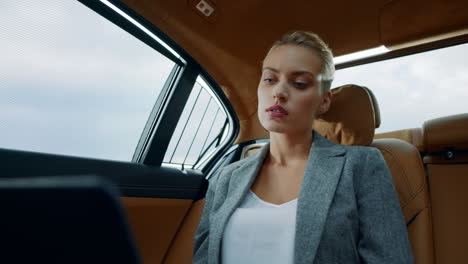 focused business woman working computer at car. serious girl typing laptop