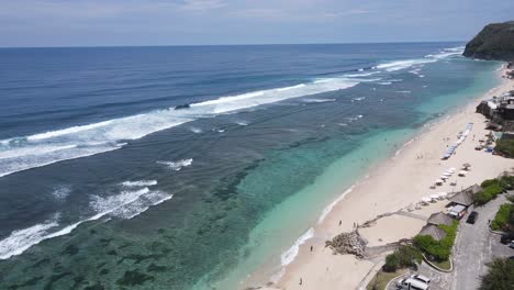 a stunning aerial view of melasti beach, bali, showcasing turquoise waters, rugged cliffs, and serene coastline