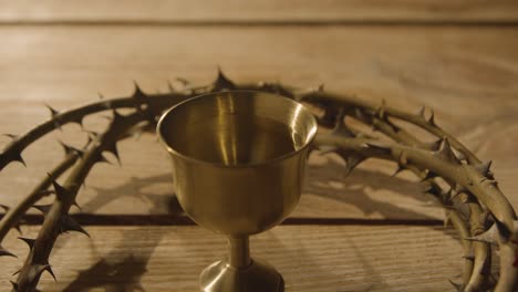 toma de concepto religioso de cáliz con corona de espinas colocada alrededor sobre fondo de madera 1