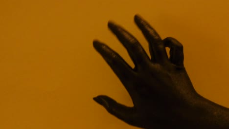 mujer joven pintada a mano con color negro moviéndose suavemente en un fondo amarillo