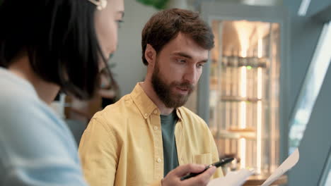 a man has a business meeting in a coffe shop with an young woman