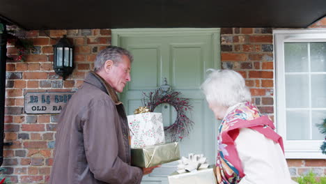 senior parents being greeted by adult offspring as they arrive for visit on christmas day