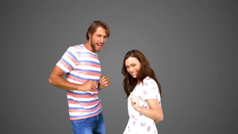 two friends dancing together on grey background