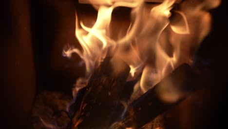 slow-motion flames dancing over burning logs, capturing the mesmerizing movement and intensity of fire.