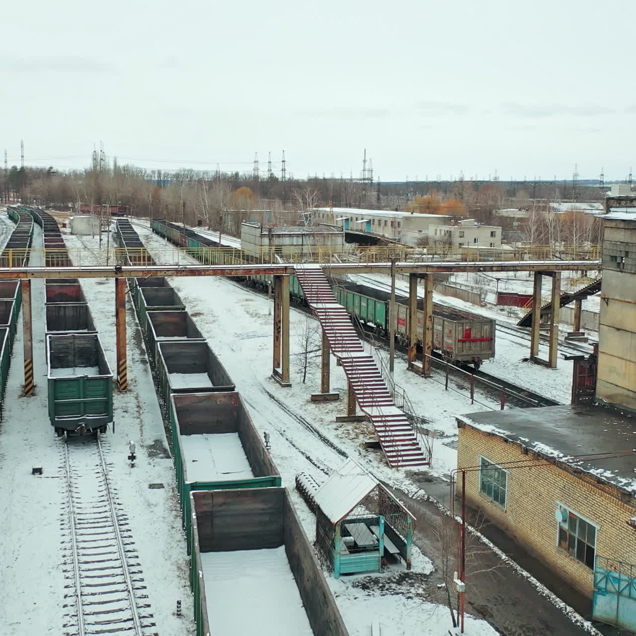 Four rows of containers are located at the railway station near the state building outside the city. Aerial view.