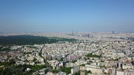 Aerial-panoramic-footage-of-metropolis,-buildings-in-urban-boroughs.-Vast-woodland-Bois-de-Boulogne-and-dominant-Eiffel-Tower-in-distance.-Paris,-France