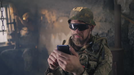 soldier using a smartphone in a war zone