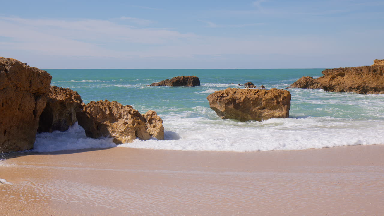 Vagues puissantes sur les stacks marins de la plage de Praia do Evaristo en Algarve, Portugal.
