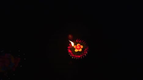 loy krathong festival: top down view of colorful krathong floating on the dark blue water on the lake