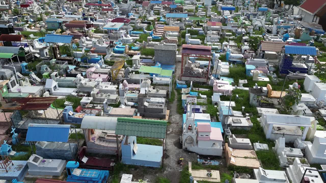 Drone footage of colorful graves and tombstones in a densely packed cemetery