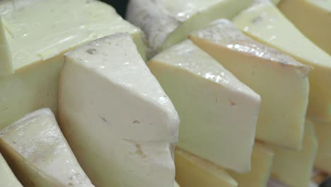 close up of cheese wheels and slices