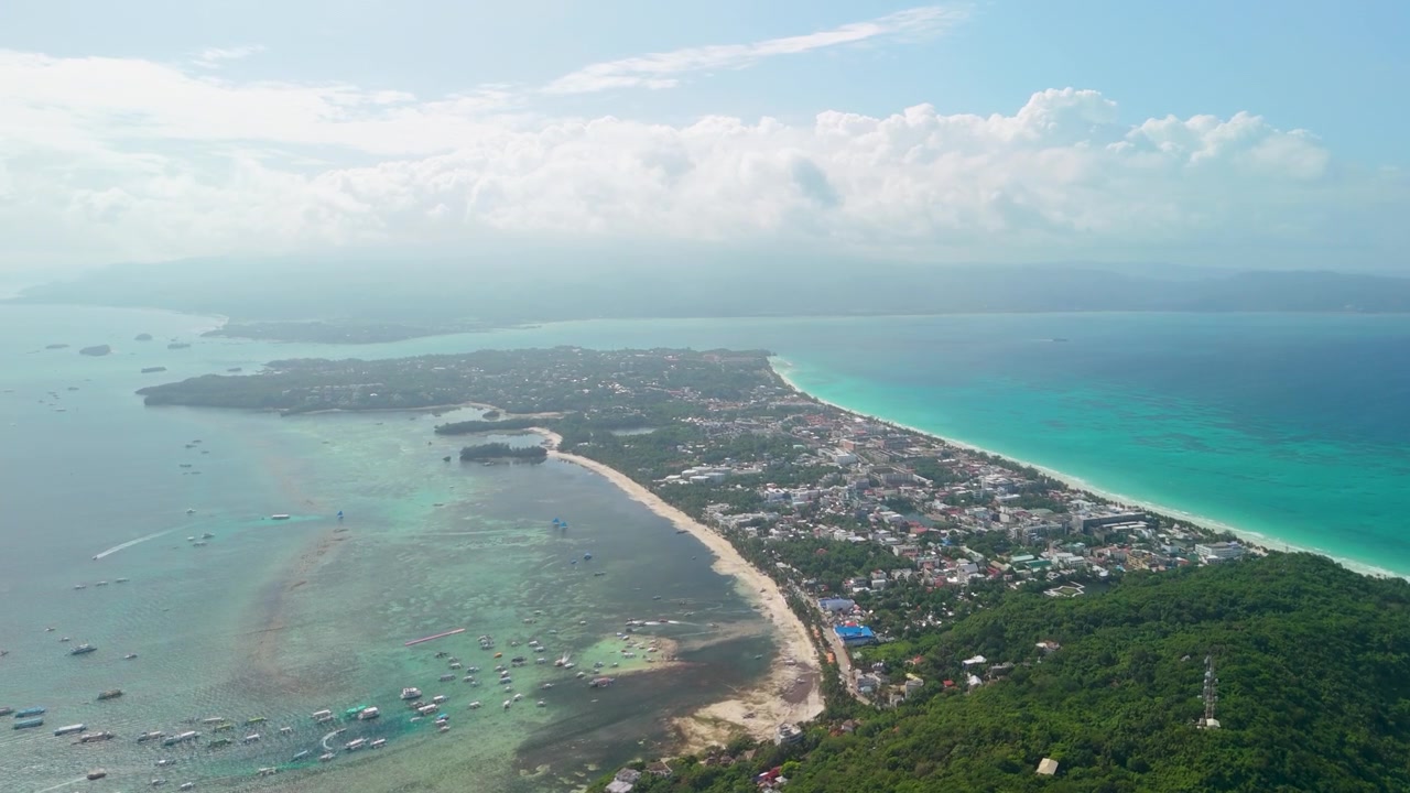Paesaggio urbano aereo ad alta quota dell'isola di Boracay rivela la spiaggia di Bulabog, la baia di Habagat, una densa città turistica, il Mar di Sulu turchese e decine di barche ormeggiate in acque calme
