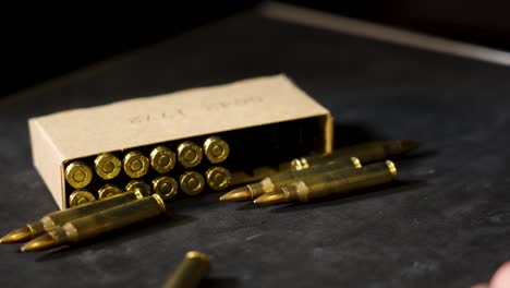 ammunition rolls across frame to a pile near boxed rounds.