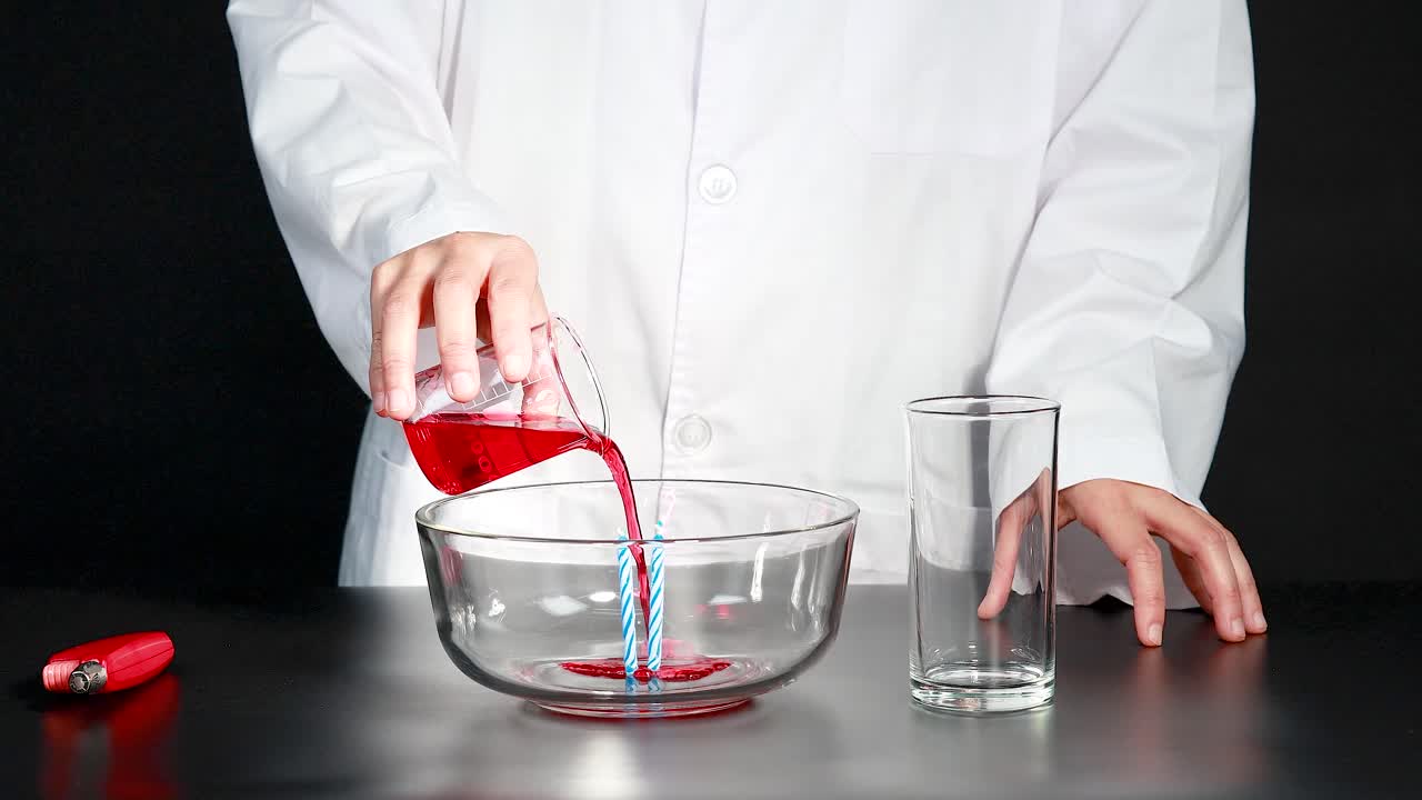 un científico demuestra una reacción química usando una vela, un vaso y un líquido de color, ilustrando las diferencias de presión