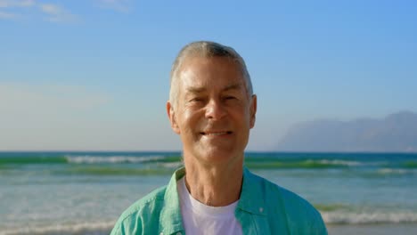 front view of active senior caucasian man standing on the beach 4k