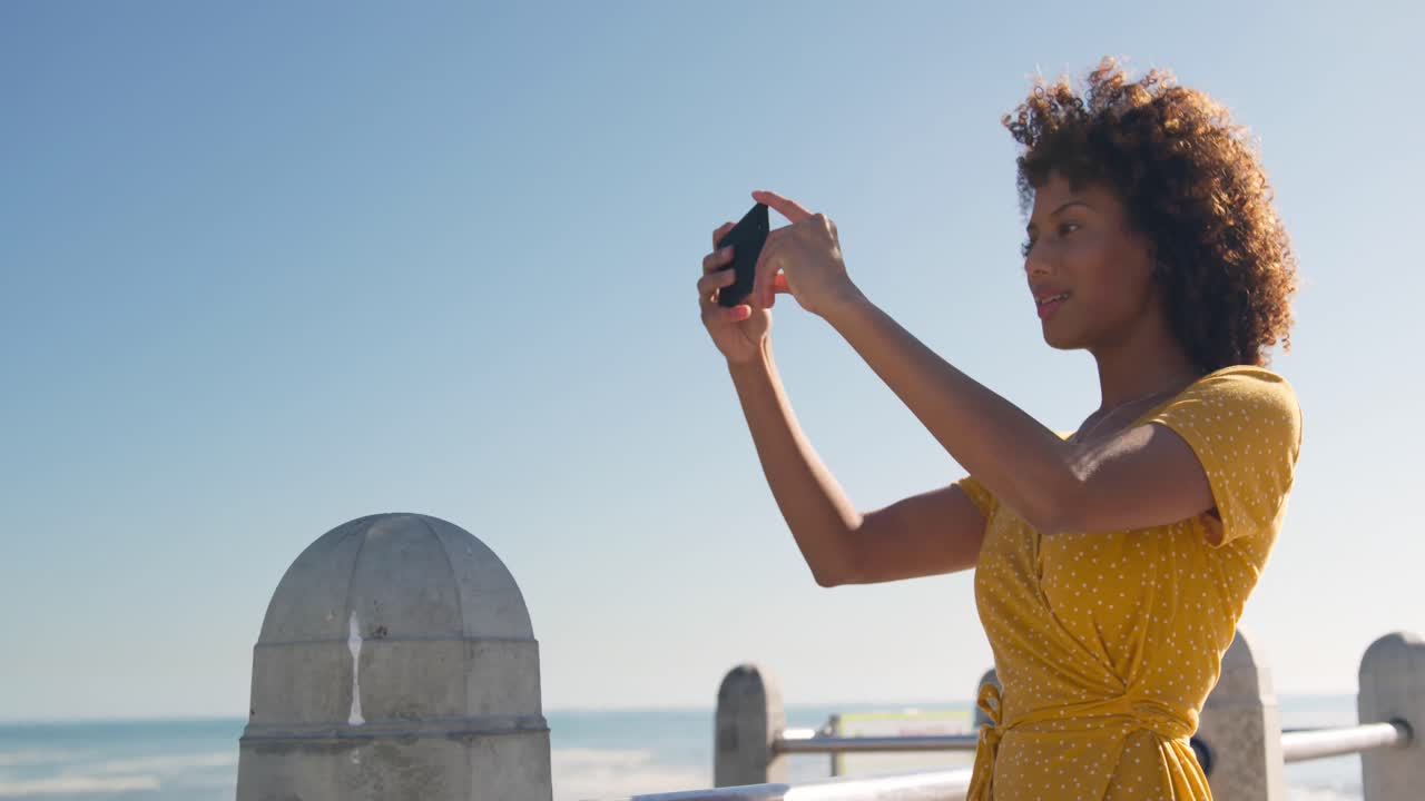 Woman taking video at beach