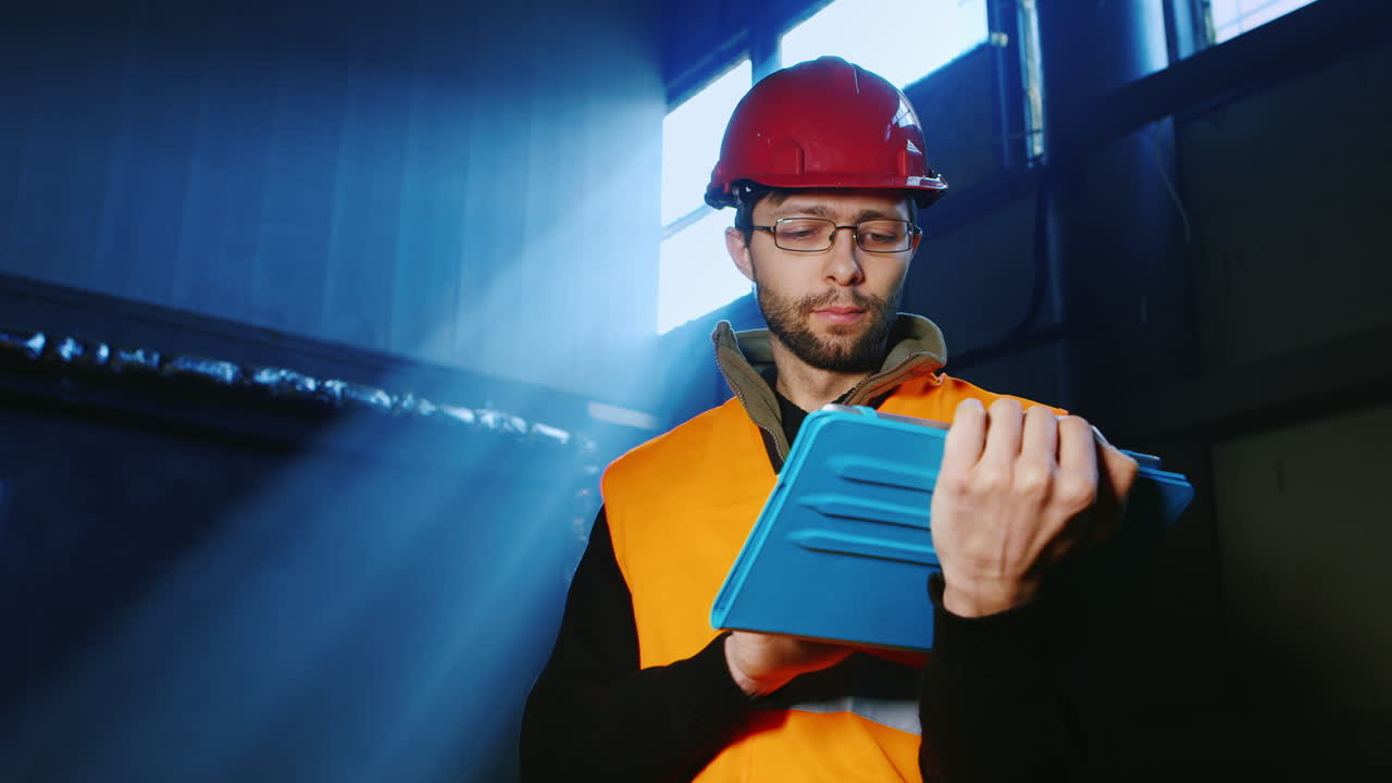 un ingeniero trabaja en un almacén y usa una tableta 14