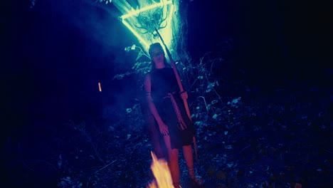 woman with glowing staff in the forest at night