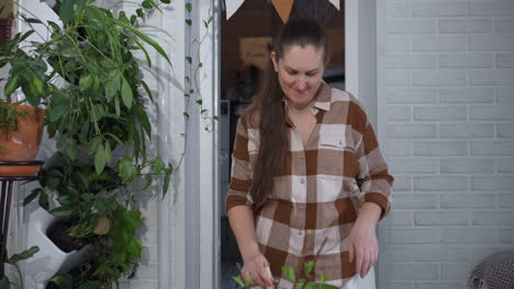 plant lover dancing with excitement holding small shovel beside lush potted greenery in white painted room, swaying to gardening rhythm with joyful smile and cozy indoor plant decor vibe