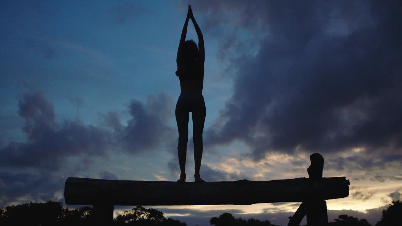 젊은 여성의 실루 ⁇  요가 포즈 명상 여성 균형 저녁 황혼 배경