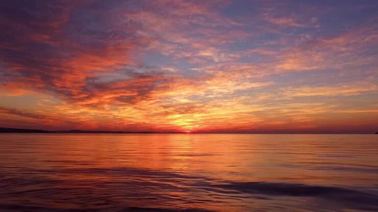A Breathtaking Transition of Colors in a Sunset Over Calm Waters, Capturing the Serenity and Beauty of Nature's Evening Palette