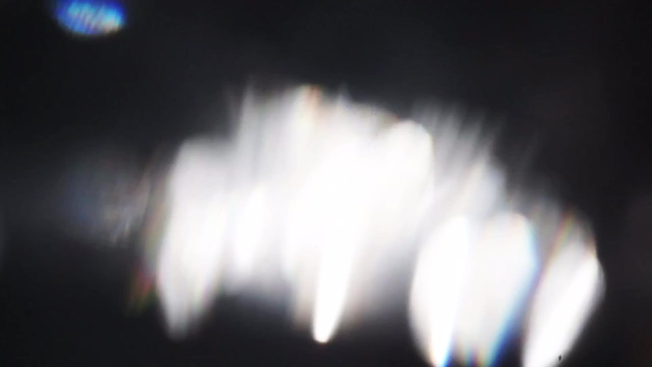 Abstract Optical Light Flares Moving and Fading on Dark Background