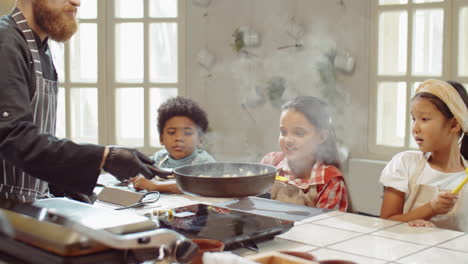 kids watching chef tossing food in skillet on cooking masterclass