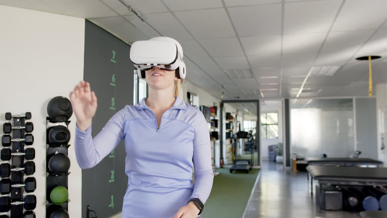 Žena v rehabilitačním centru používající VR headset, zapojující se do virtuální terapie.